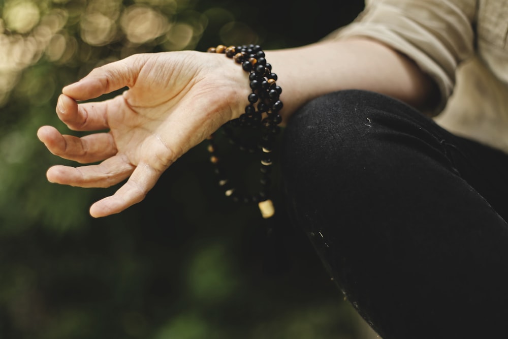 Hand mit Mala-Kette bei der Meditation